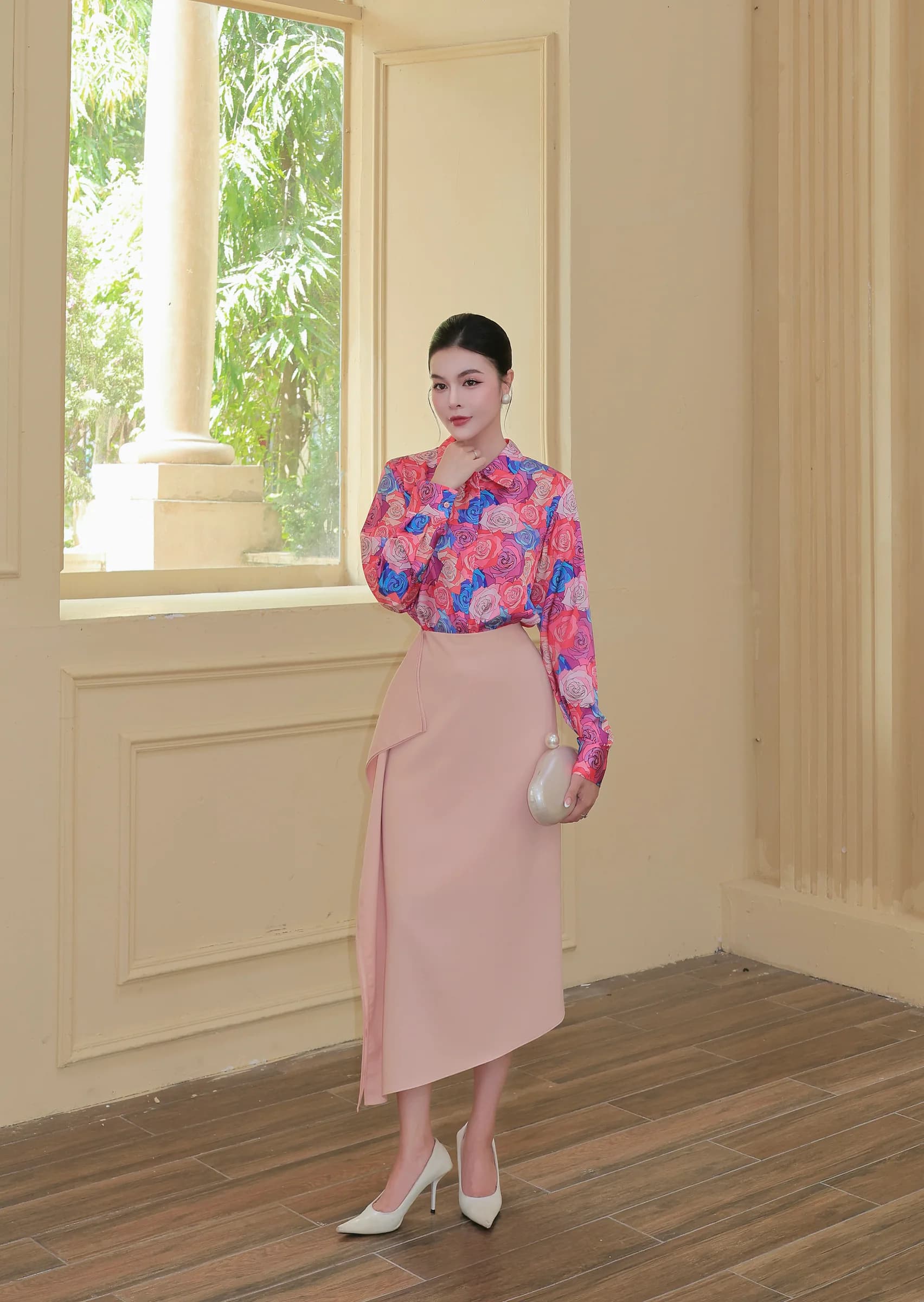 Người mẫu Maison Élégant trong sơ mi hoa và chân váy midi tại không gian sáng màu.